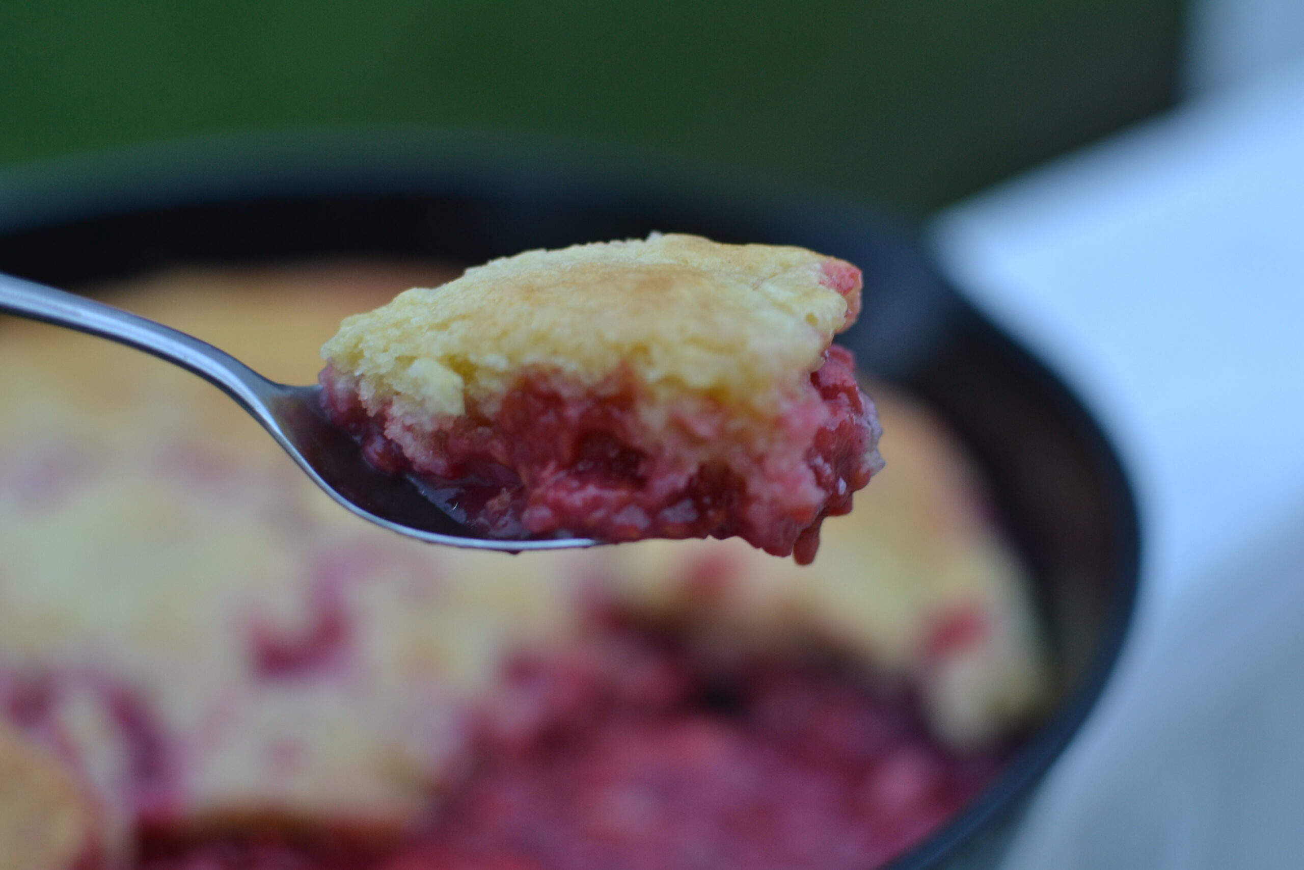 Close up of a bite of Raspberry cobbler on a spoon