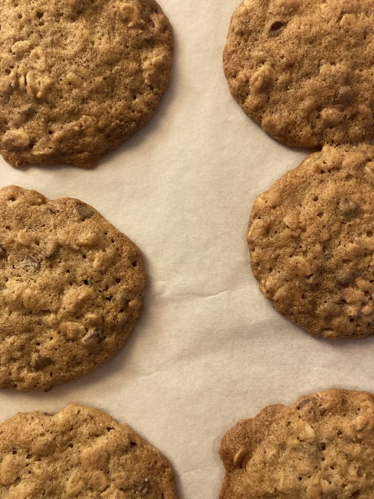 Oatmeal cookies on white parchment paper on a cookie sheet