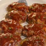 Mini Meat Loaves on a white place with sauce on the top