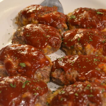 Mini Meat Loaves on a white place with sauce on the top