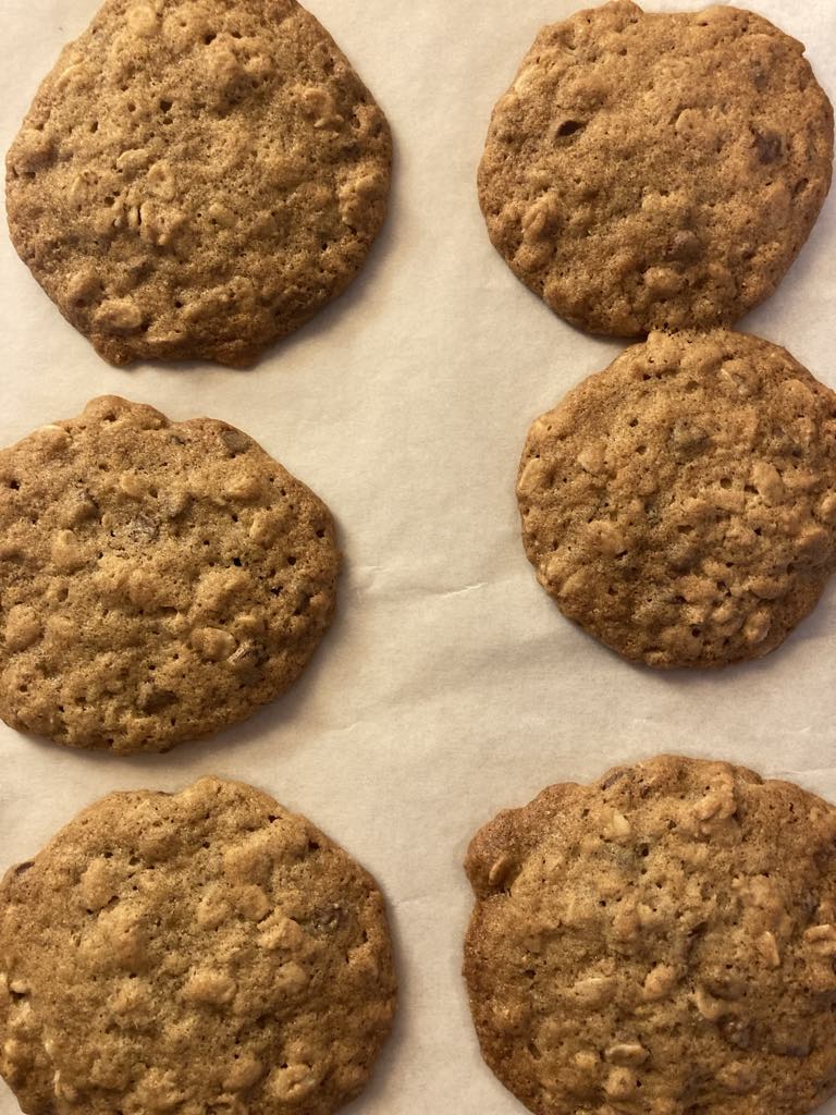 Oatmeal cookies on white parchment paper on a cookie sheet