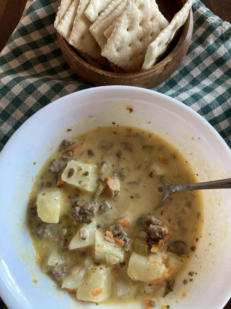 Cheeseburger soup in a white bowl