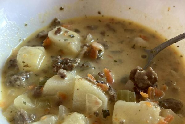 Cheeseburger soup in white bowl