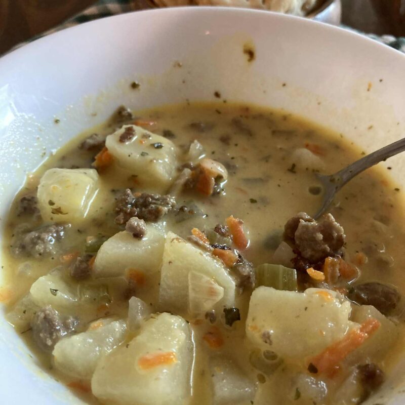 Cheeseburger soup in white bowl