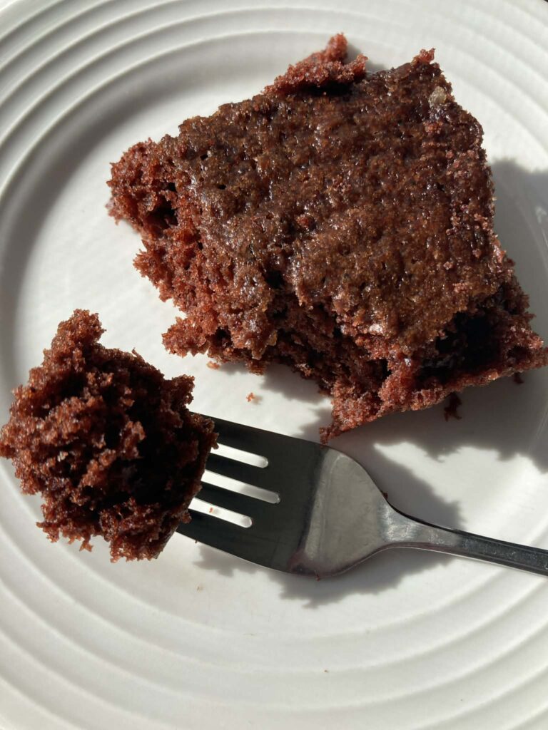 Square piece of chocolate salad dressing cake on white plate