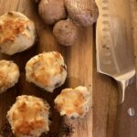 Cream cheese stuffed mushrooms on a cutting board